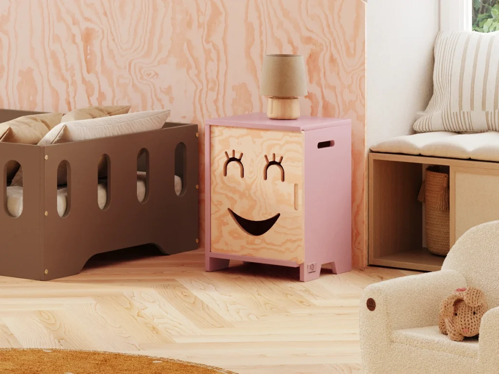 Armoire pour enfants en bois avec un visage souriant aux yeux fermés s’ouvrant vers la droite en couleur rose