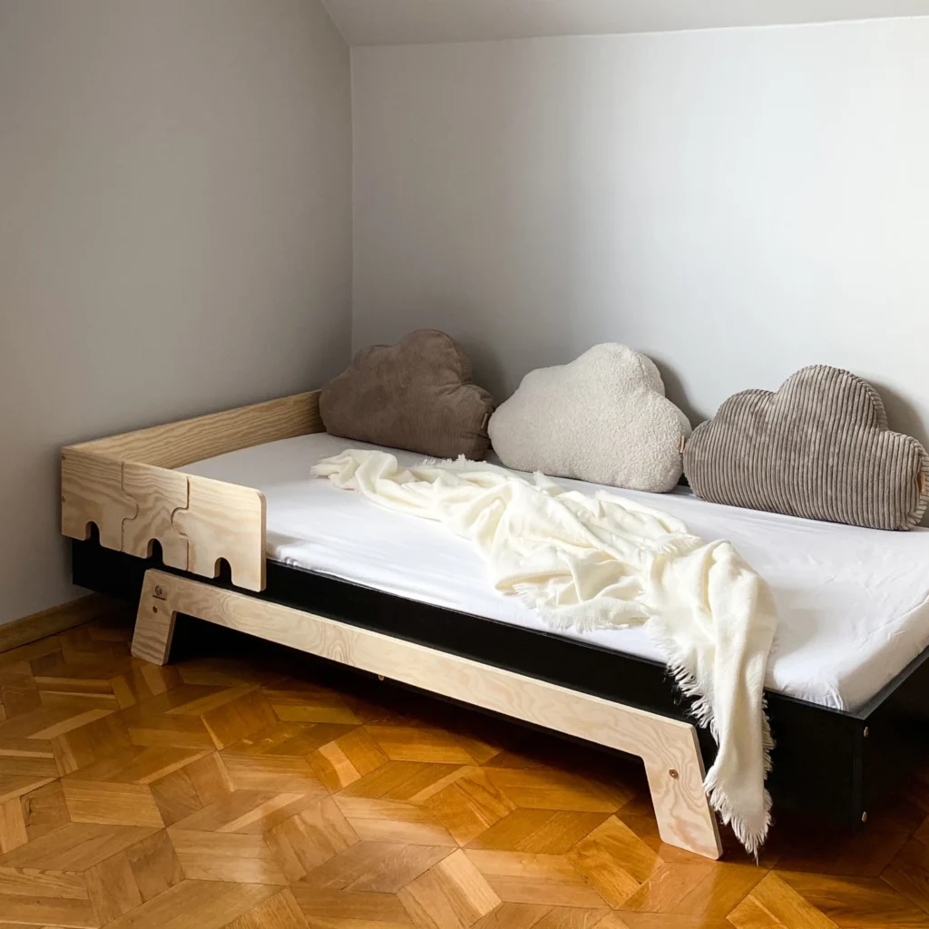 Lit en bois fabriqué en contreplaqué de pin de couleur noire avec une barrière en forme de puzzle