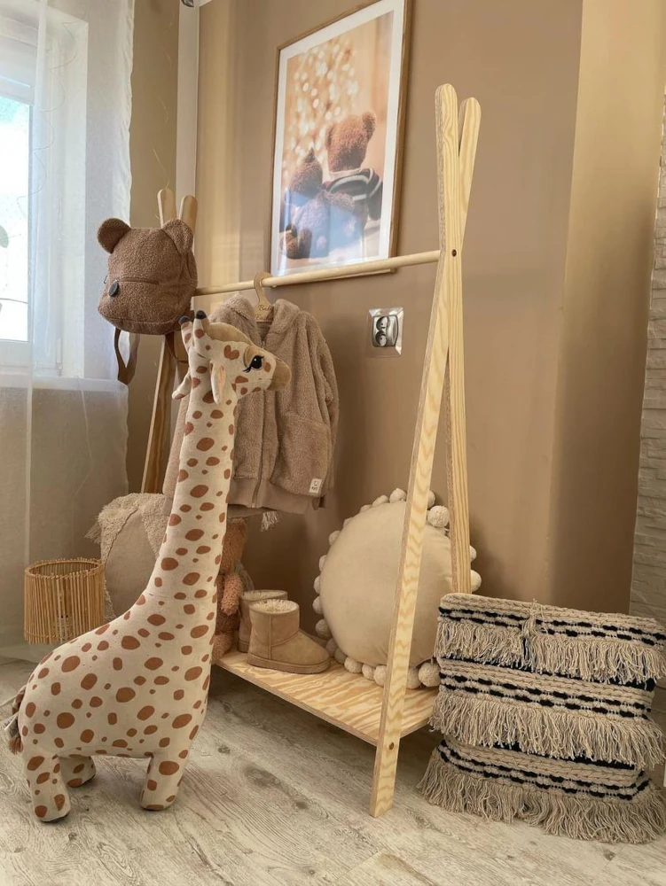 Porte-manteau en bois en forme de tipi avec des vêtements pour enfants suspendus