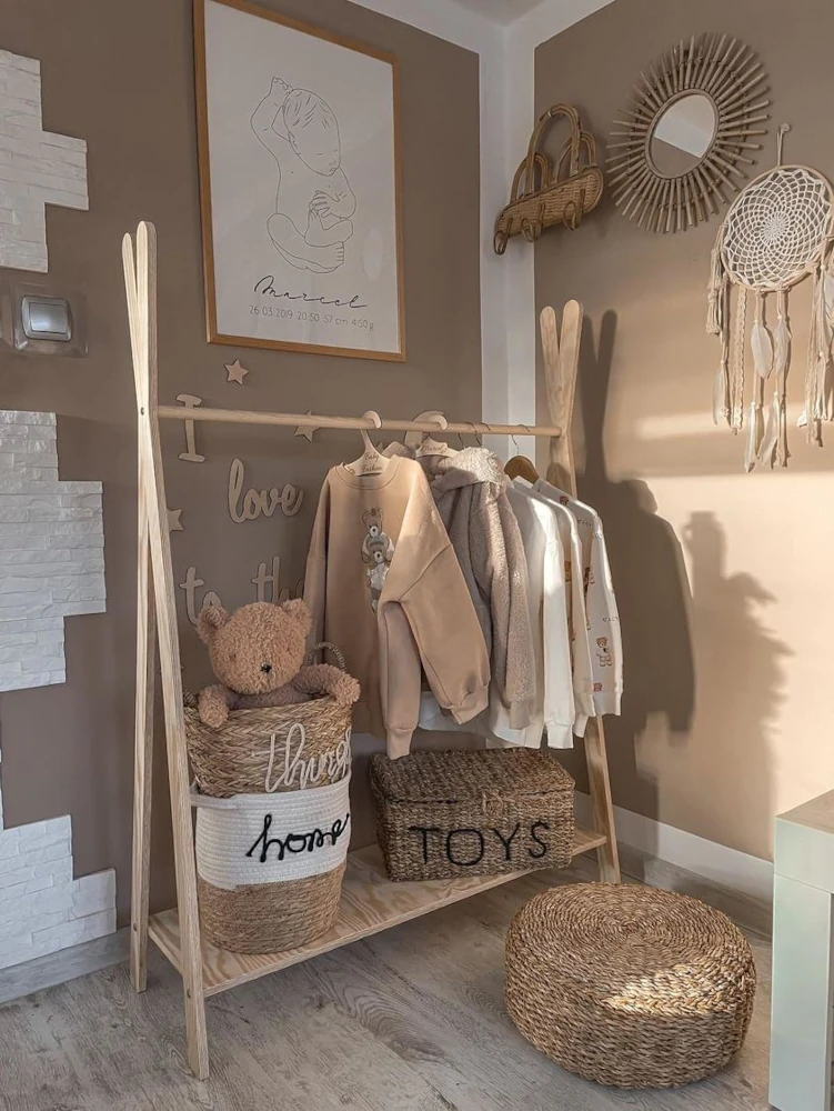 Porte-manteau en bois en forme de tipi avec des vêtements pour enfants suspendus