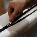 Gros plan sur un matelas enfant blanc avec housse zippée amovible.