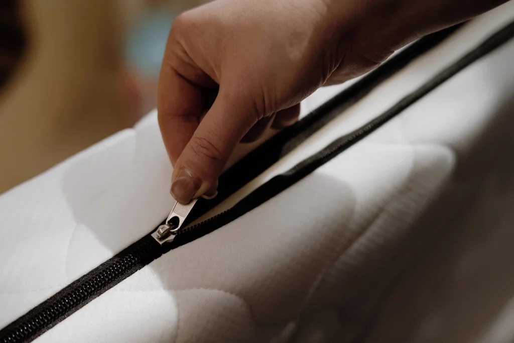 Gros plan sur un matelas enfant blanc avec housse zippée amovible.