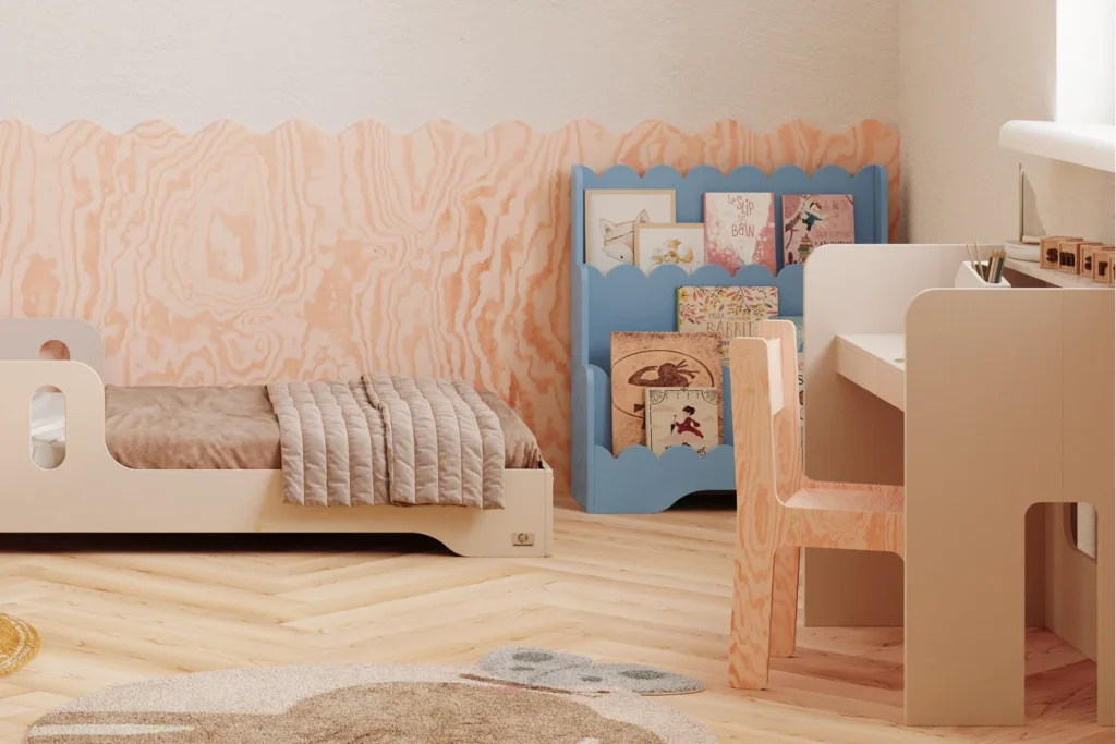 Chambre d’enfant avec un lit blanc et un bureau blanc. Près de la fenêtre se trouve une bibliothèque Lulu bleue à trois étagères, remplie de livres colorés. Mur avec motif en bois et sol clair.