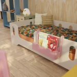 Décoration Lulu rose sur lit d’enfant, chambre Montessori colorée.