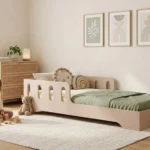 Lit enfant Smartwood TILA 6 en bois rose poudré coloris cachemire avec barrières - petite fille jouant avec des cubes en bois à côté du lit.