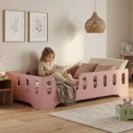 Chambre enfant avec un lit Montessori TILA 2 rose - petite fille lisant un livre dans son lit, à côté d'un lit miniature MINI TILA pour poupées