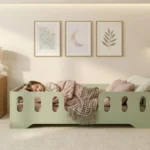 Chambre enfant avec un lit Montessori TILA 2 vert avec barrière – petite fille dormant paisiblement dans son lit sécurisé