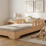 Chambre enfant avec un lit Montessori TILA 6 en bois naturel avec barrière – petite fille jouant avec des blocs en bois à côté de son lit