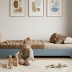 Lit au sol Smartwood TILA 7 en bois bleu de style Montessori — petite fille jouant avec des cubes en bois à côté du lit.