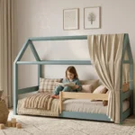 Lit cabane MILO en bois bleu sauge doux, fillette lisant un livre dans un cocon douillet avec baldaquin et coussins.