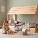 Lit cabane Smartwood MOON M en bois naturel - petite fille jouant avec des cubes en bois à côté du lit.