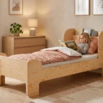 Lit enfant Smartwood FLOU en bois naturel dans une chambre lumineuse - petite fille lisant un livre dans le lit, mobilier sain et écologique.