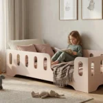 Lit enfant TILA 2 couleur cachemire avec barrières, fillette lisant un livre dans une chambre Montessori claire et chaleureuse.