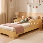 Lit enfant TILA 6 jaune beurre avec barrières ajourées, un enfant dort blotti contre un ours en peluche.