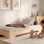 Lit enfant TILA 7 en bois naturel, conception basse au sol, une fillette construit une tour de cubes près du lit.