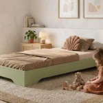 Lit enfant TILA 7 bas en bois vert sauge, fillette jouant avec des cubes près du lit dans une chambre lumineuse