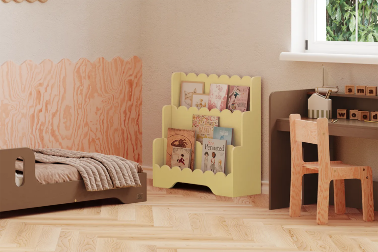 Bibliothèque Lulu jaune beurre avec livres, placée entre un lit enfant et un bureau en bois