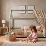 Lit cabane MILO vert avec ciel de lit en tissu et barrière en bois, petite fille qui joue aux cubes sur le tapis devant le lit.