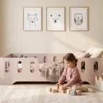 Lit enfant TILA 2 coloris cachemire avec barrières ajourées, petite fille jouant aux cubes sur le tapis.