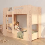 Lit superposé MIMI B coloris naturel avec échelle et couchage du bas en forme de cabane, petite fille assise qui lit un livre.