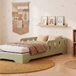 Matelas Smart Comfort avec housse déhoussable à fermeture éclair, posé sur le lit enfant TILA 6 vert dans une chambre lumineuse.